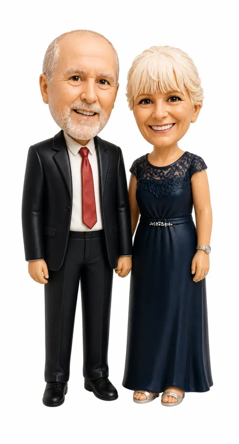 Bobblehead na preview ng isang lalaking may malaki at bilog na ulo, kalbo sa ibabaw na may maikling kulay-abong buhok sa mga gilid at puting balbas, naka-itim na suit at pulang kurbata, katabi ang isang babaeng may maikling maputlang blonde na buhok na naka-navy na lace dress