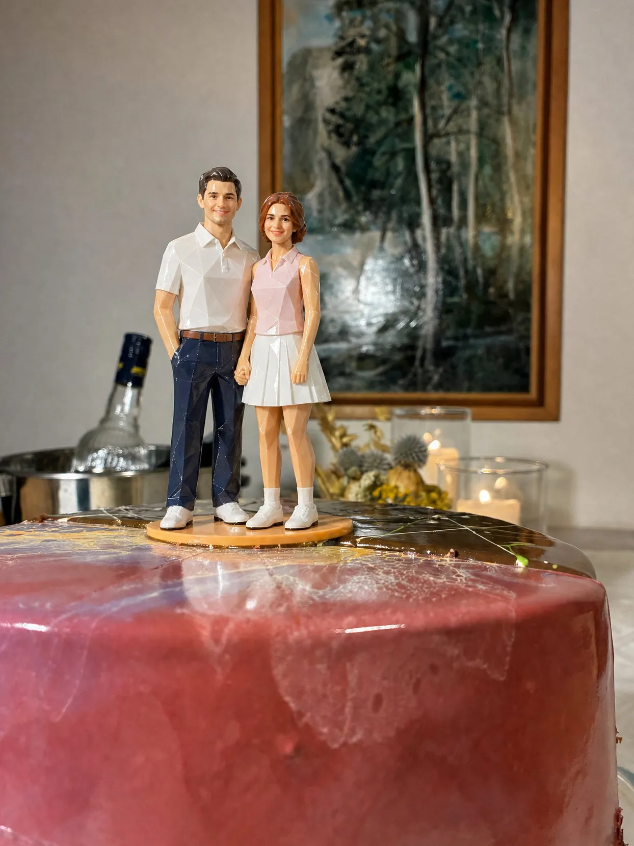 The same topper couple: he in a white polo and navy trousers, she in a pink polo and a white pleated skirt, on a pink cake.