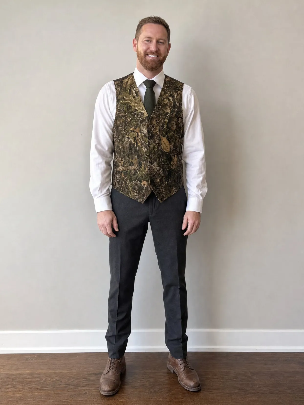 Der Mann vom Paarfoto in derselben Weste, demselben Hemd, Krawatte, Hose und Stiefeln vor einer schlichten Wand.
