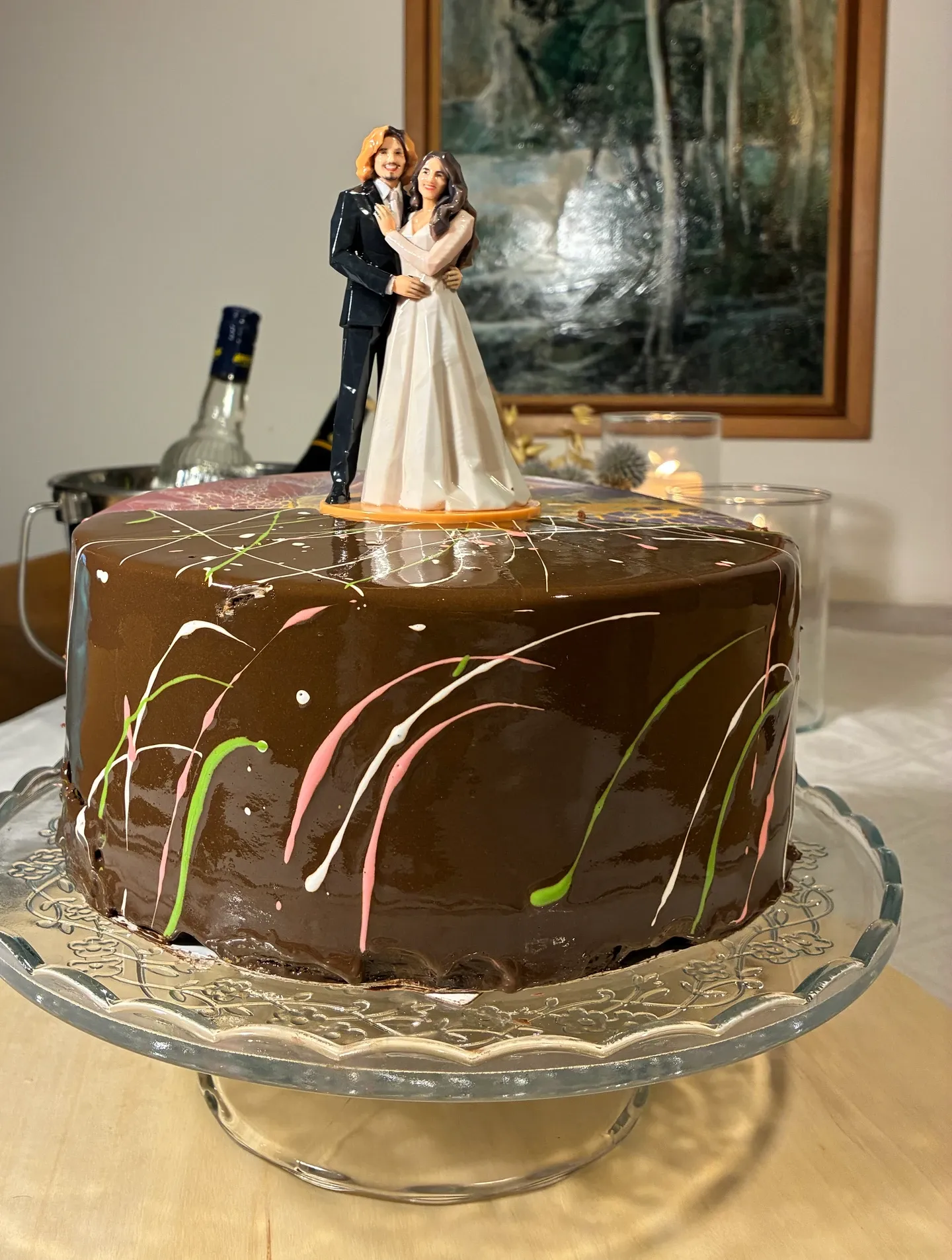 Una figura impresa brillante de novios sobre una base ovalada naranja, encima de un pastel de chocolate